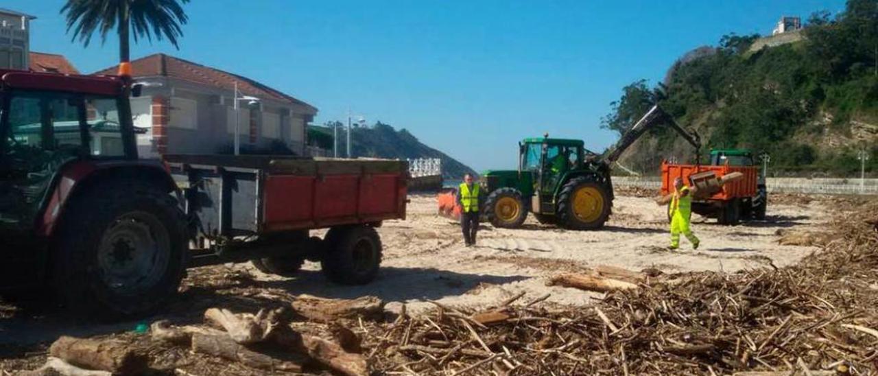 Una laboriosa tarea. Tres de los cuatro tractores que realizan estos días las labores de limpieza en la playa de Santa Marina, en Ribadesella.
