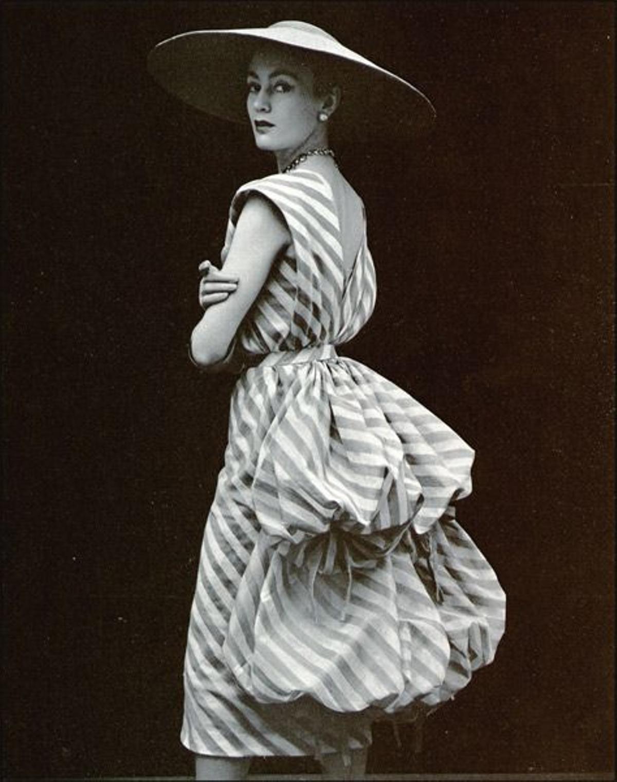 VOLÚMENES ABULLONADOS:Vestido de cóctel de tafetána rayas, de 1951.