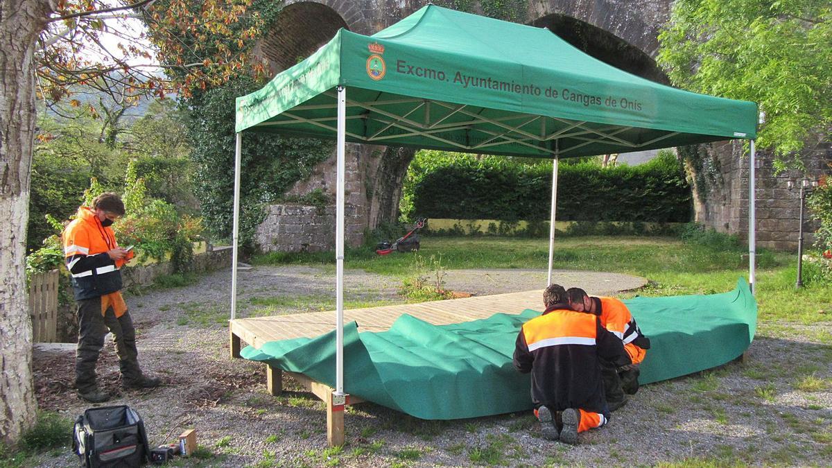 Operarios, ayer, ultimando los preparativos para la entrega del premio, ante el “puente romano” de Cangas de Onís. | J. M. C.