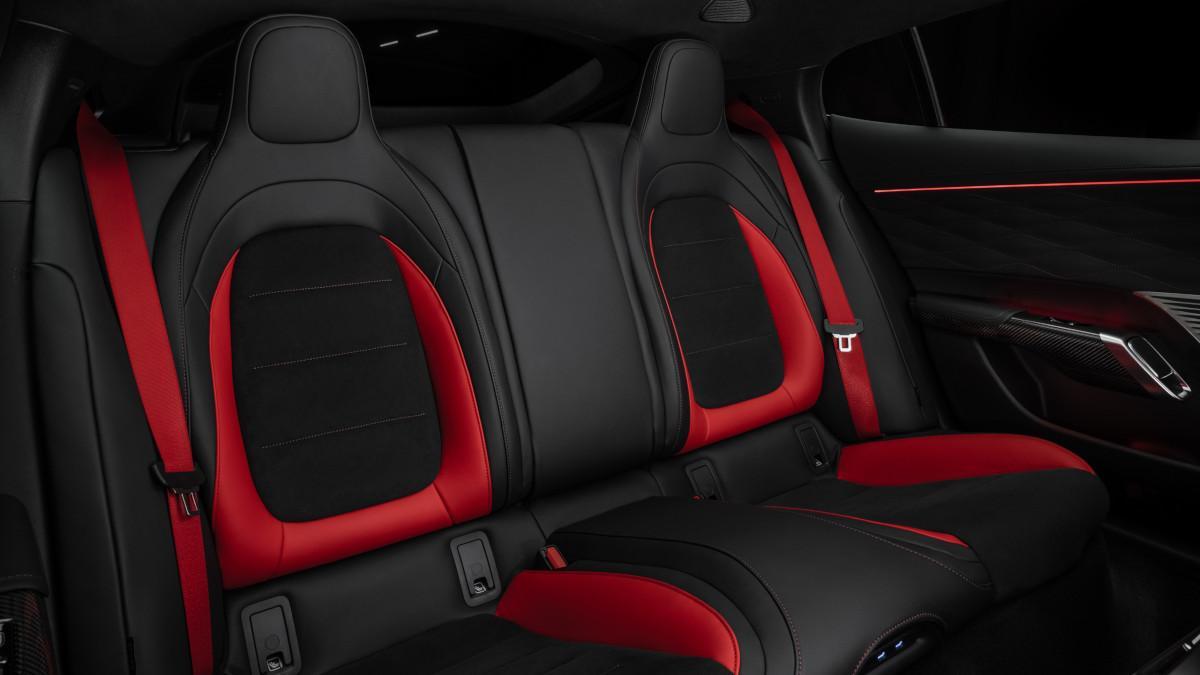 Las plazas traseras buscan un punto más cómodo de gran turismo, con asientos individuales, buen espacio y detalles deportivos en rojo.