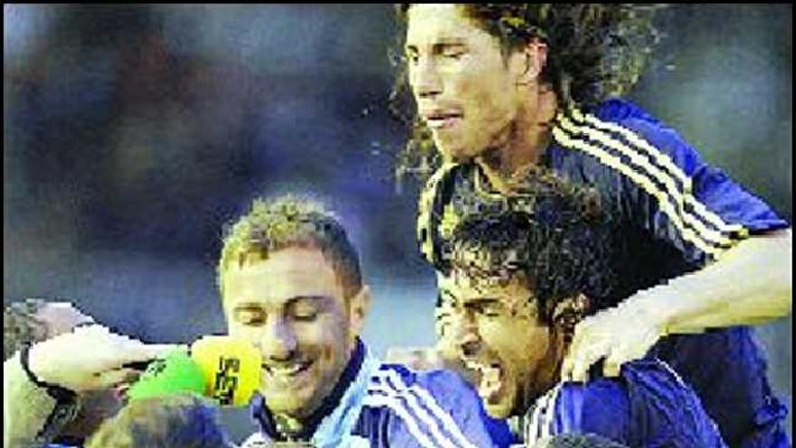 Robinho, Raúl, Sergio Ramos y Dudek saltan sobre Higuaín, tras anotar éste el segundo gol del Real Madrid, en Santander, el pasado domingo.