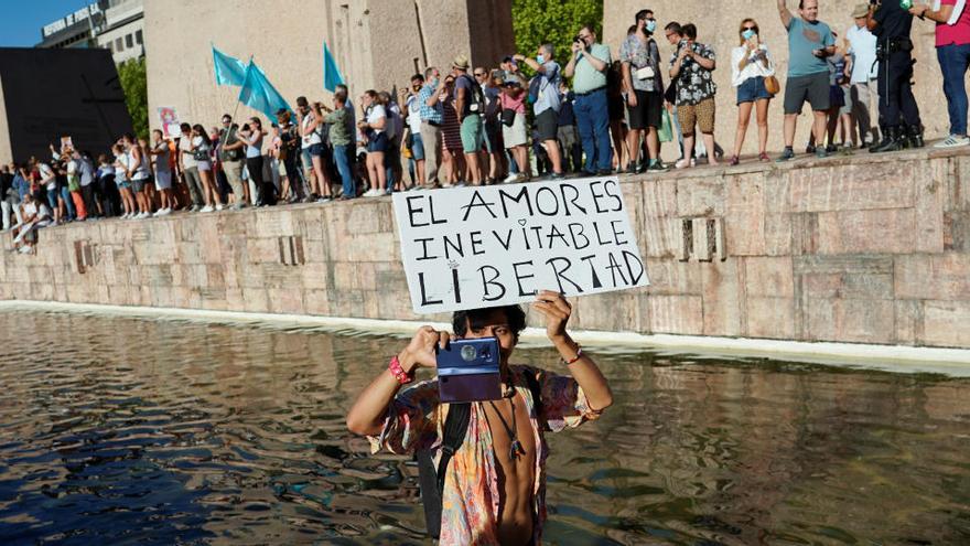 Un hombre se baña en una fuente durante la concentración