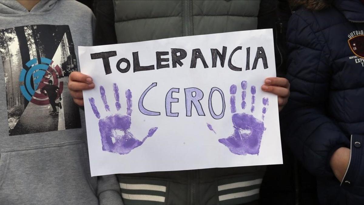 Un manifestante sostiene una pancarta que exige tolerancia cero.