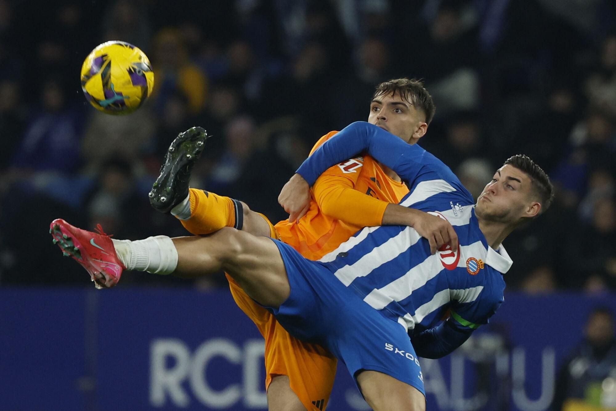 Real Madrid's Raul Asencio, left, challenges for the ball with Espanyol's Roberto Fernandez during a Spanish La Liga soccer match between Espanyol and Real Madrid at the Lluis Companys Olympic Stadium in Barcelona, Spain, Saturday Feb.1, 2025. (AP Photo/Joan Monfort)