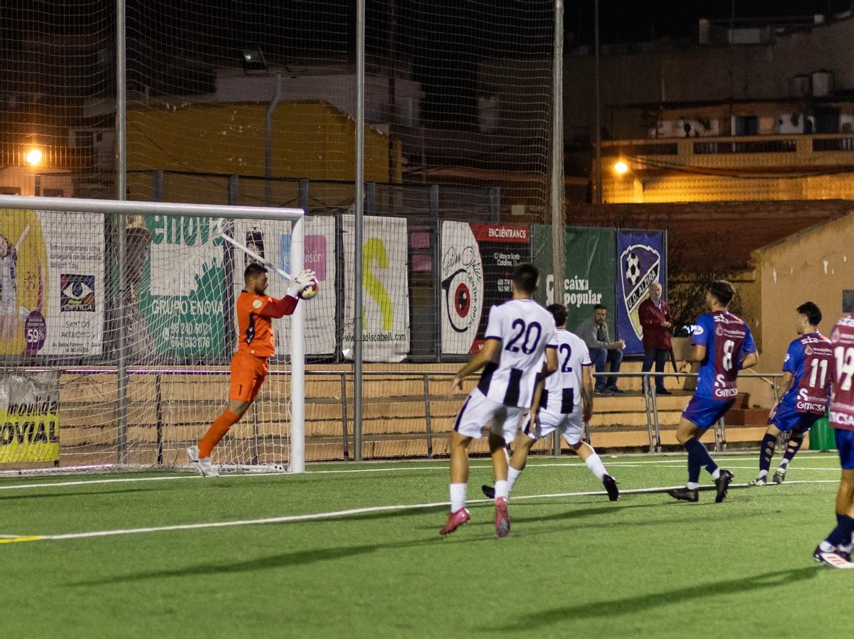 El meta visitante detiene un balón.