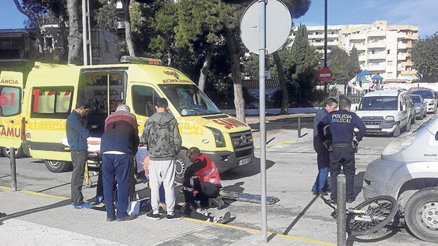 Varias personas observan a los sanitarios atender al ciclista que resultó herido.