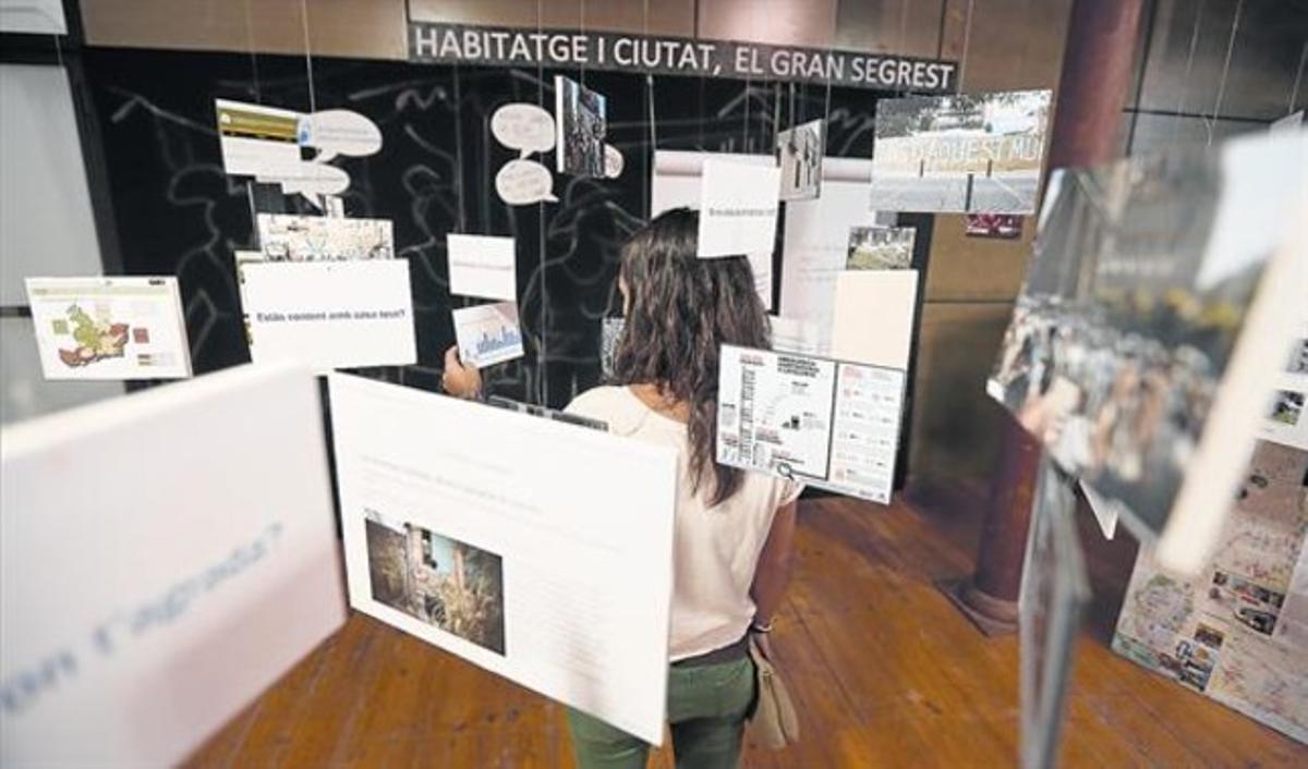 Una jove consulta un dels espais de l’exposició de La Farinera del Clot, crítica amb la imatge més divulgada de la ciutat.