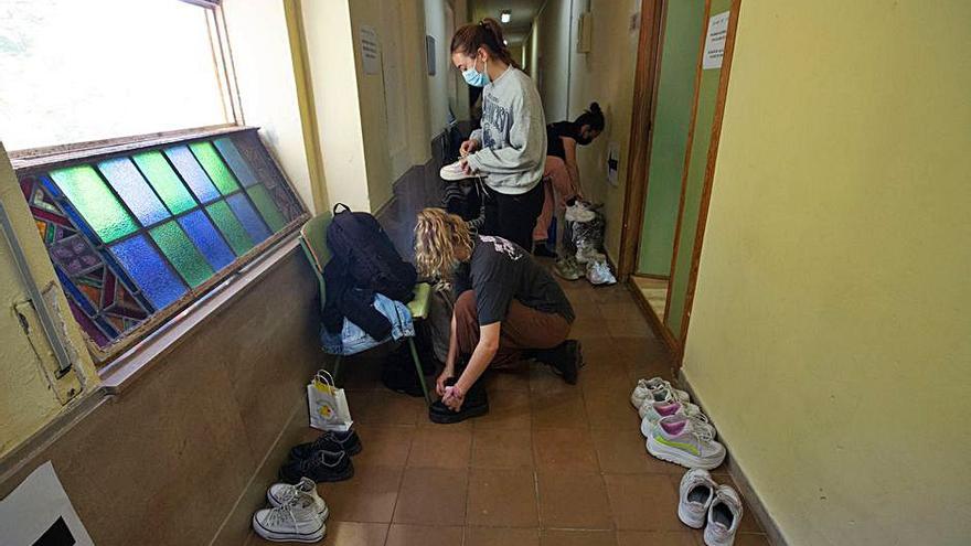 Alumnas se calzan tras la clase. Los zapatos se iienen que dejar en los pasillos.. | RAFA ARJONES