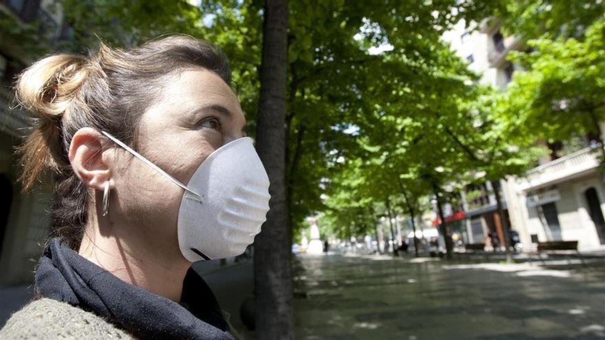 Una joven se protege con una mascarilla del polen.