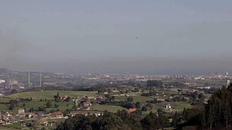 La ciudad de Gijón, al fondo a la derecha, cubierta por una capa de contaminación el pasado mes de febrero. A la izquierda, el área industrial del concejo.