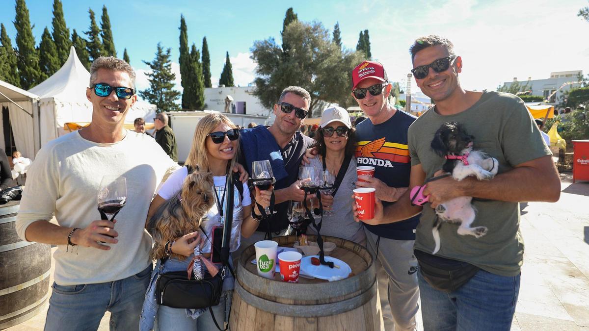 Unos asistentes a la feria brindan con los vinos locales que están catando.