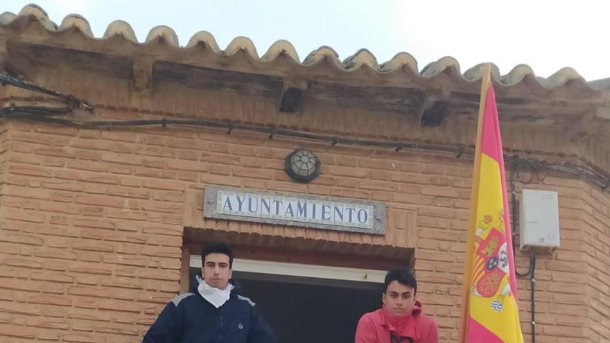 Víctor y David cuelgan su pancarta en el Ayuntamiento de Prado, Zamora.