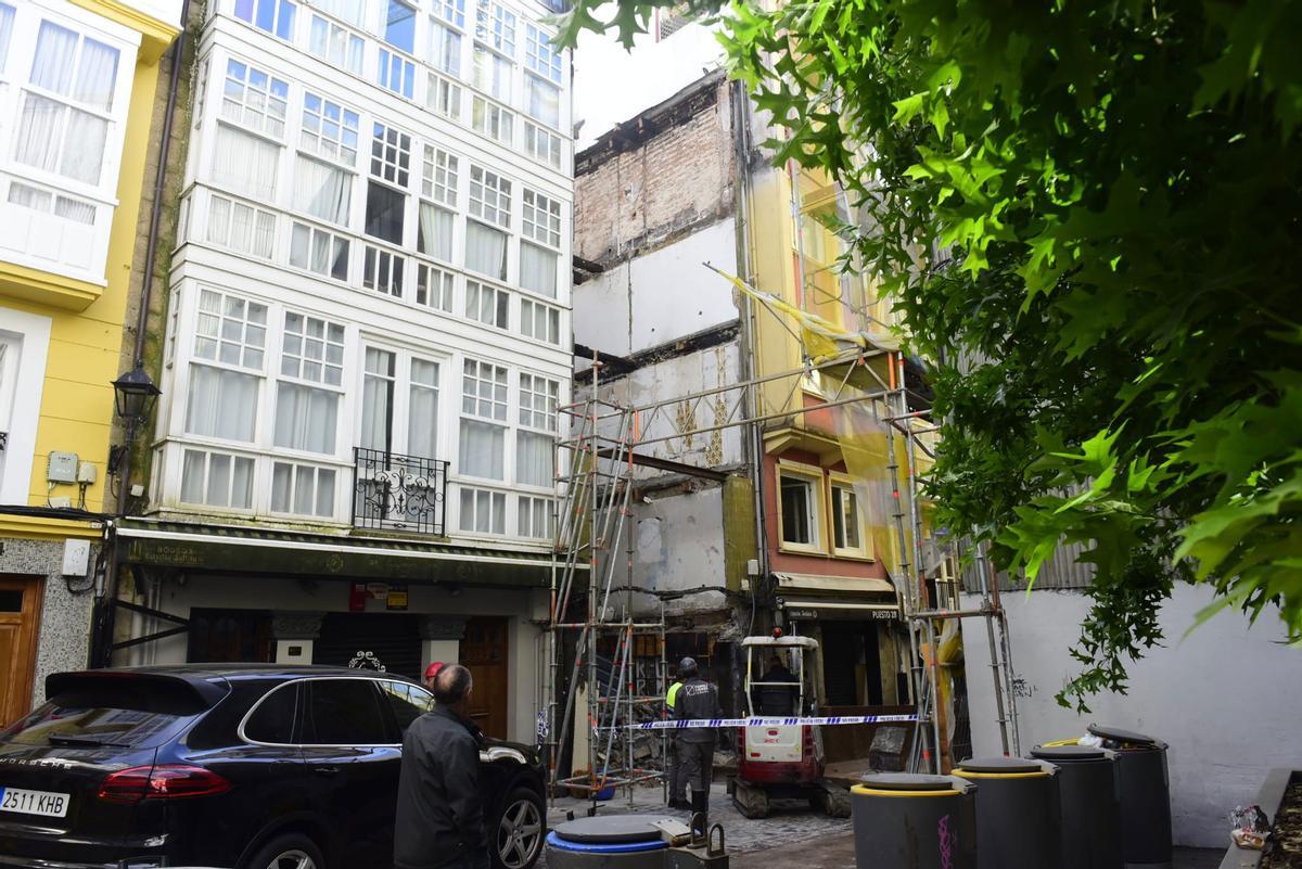 Precinto policial en la zona donde los operarios de la empresa de demolición retiran los restos y escombros.