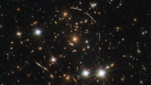 La galaxia Sunburst Arc, a 11.000 millones de años luz de distancia, captada a través del telescopio espacial Hubble gracias al efecto de las lentes gravitacionales.