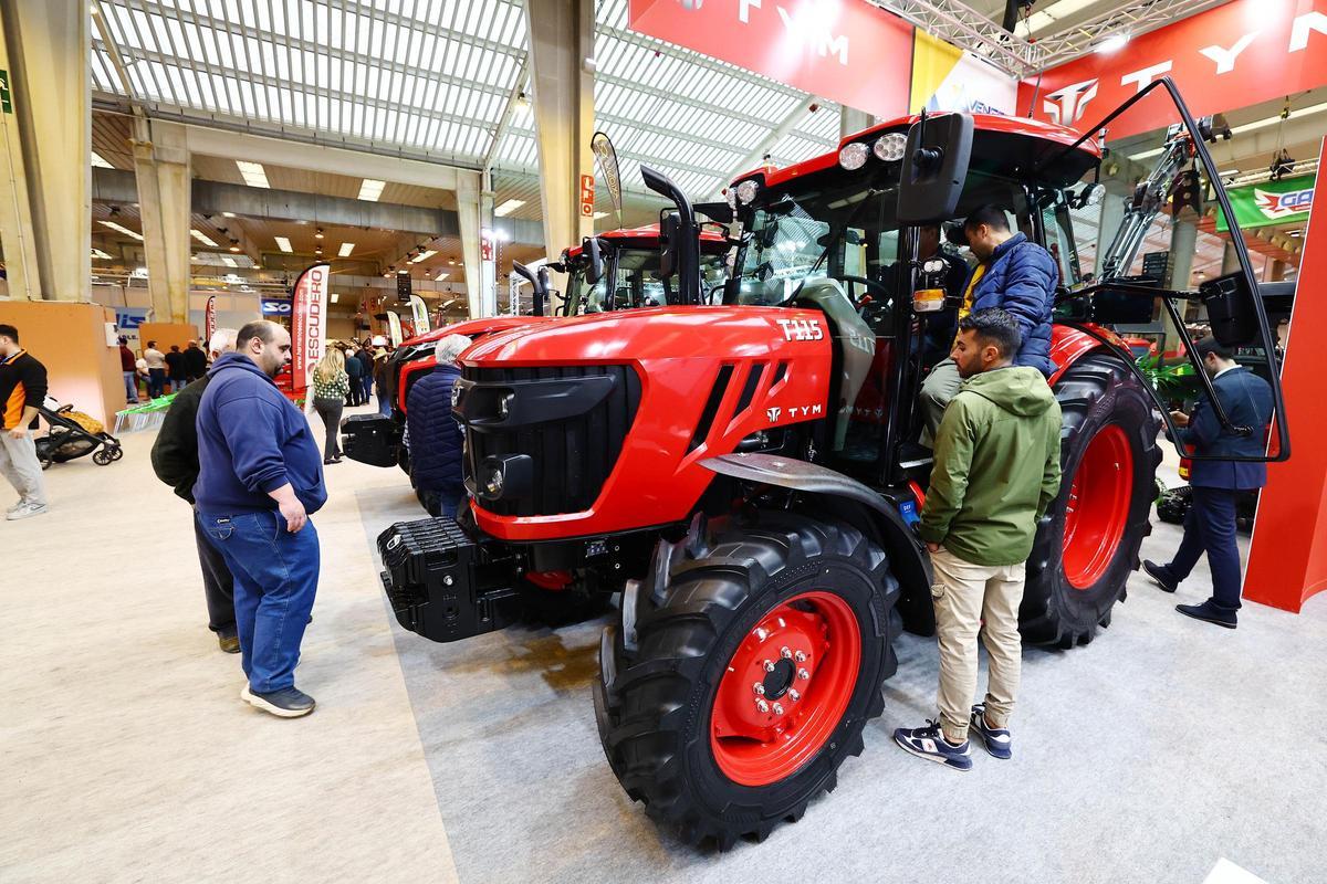 Varias personas observan uno de los tractores que se exponen en la FIMA.