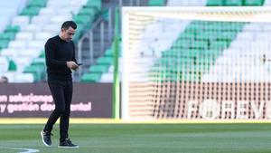 Xavi consulta el móvil antes de un partido con el Barça