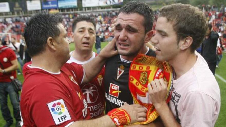 Kike García llora junto a dos aficionados del Real Murcia a la conclusión ayer del partido ante el Girona