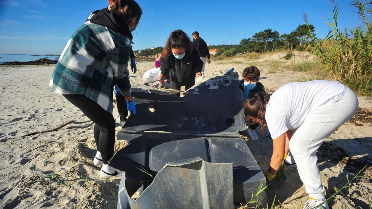 Alumnos de As Bizocas en la playa de Area da Cruz, en una jornada anterior de limpieza con Adega.  | // I.A.