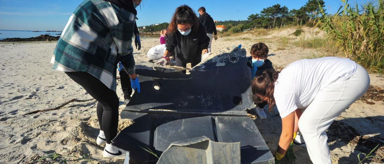 Alumnos de As Bizocas en la playa de Area da Cruz, en una jornada anterior de limpieza con Adega.  | // I.A.