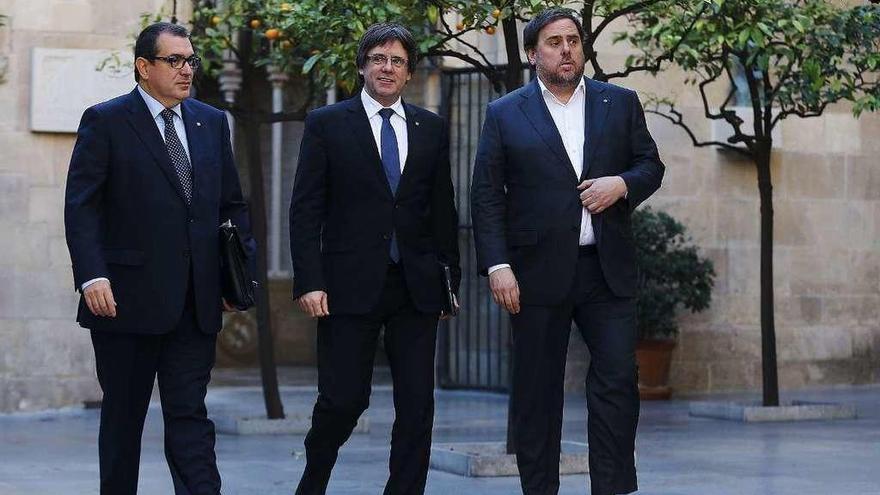 Puigdemont, flanqueado por Jané (izq.) y el vicepresidente catalán, Oriol Junqueras. // Efe