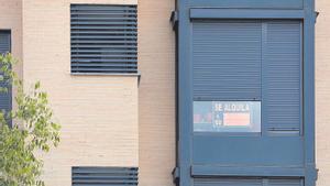 Fachada de un edificio con un cartel de se alquila