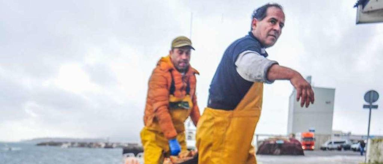 Imagen de archivo de dos pescadores de Cambados descargando su vieira en el puerto. // Iñaki Abella