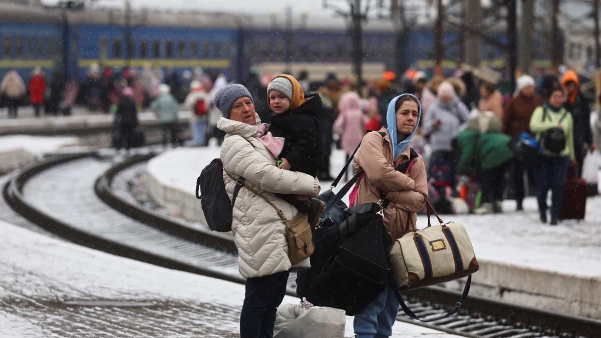 Un grupo de gente espera en la estación de Leópolis, en Ucrania, para tomar un tren que los lleve a Polonia.