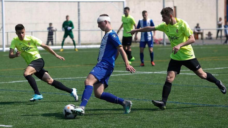 Un jugador del Avilés juvenil avanza con el balón entre dos del Sporting.