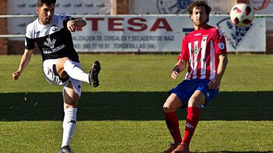 Carlos Ramos golpea el balón ante un rival.