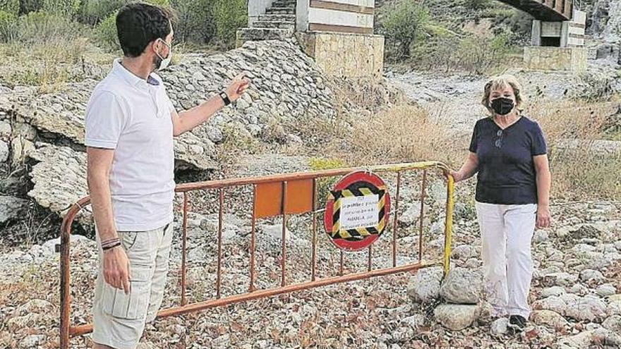 Uno vecinos muestran la valla instalada para prohibir el paso en la pasarela.