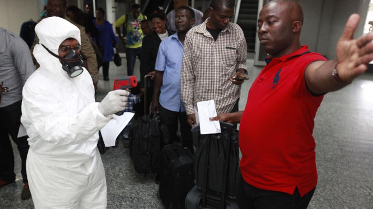 Un funcionario toma la temperatura de los pasajeros a su llegada al aeropuerto internacional de Lagos, el 6 de agosto de 2014.