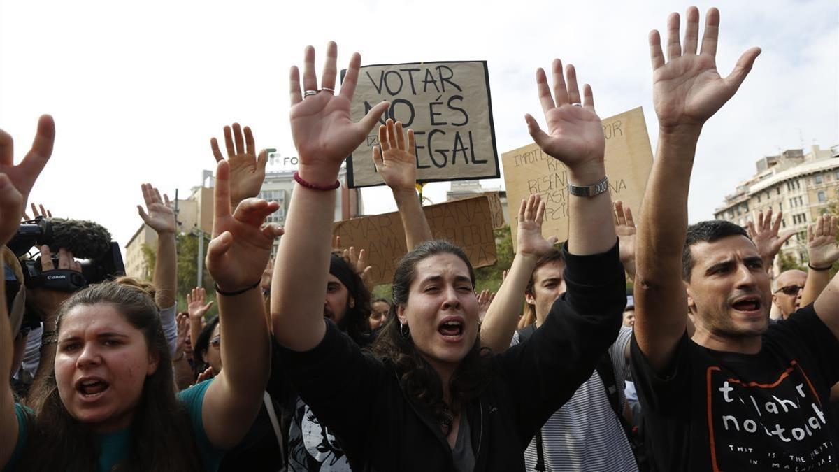 Unos jóvenes muestran su repulsa a las violentas cargas policiales de ayer, en la plaza Universitat.