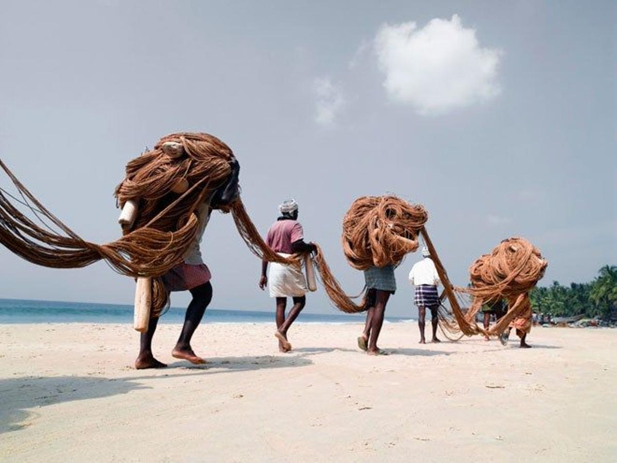Pescadores transportando las redes en una playa de Varkala.
