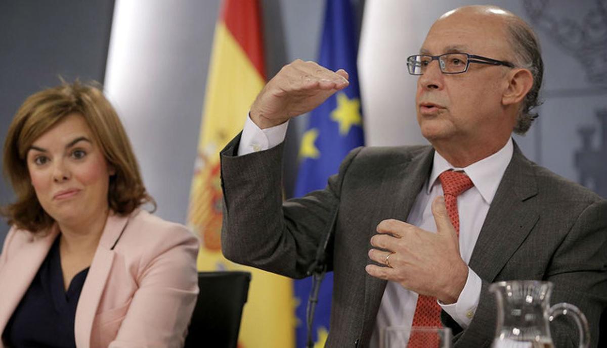 Cristóbal Montoro, amb la vicepresidenta Soraya Sáenz de Santamaría, durant la roda de premsa posterior al Consell de Ministres, ahir.