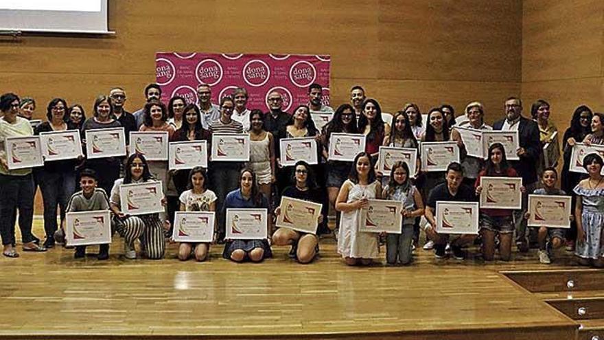 Profesores y alumnos de los colegios e institutos reconocidos posan con sus diplomas.