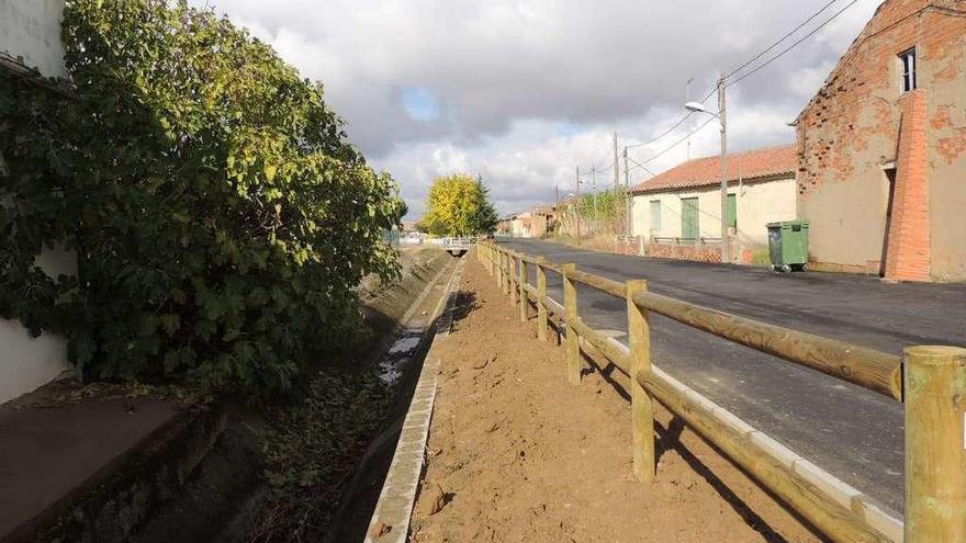 Aspecto de la pavimentación ejecutada en el acceso de Fresno con la valla rústica instalada junto al regato