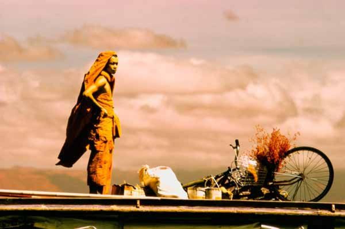 Un monje espera al ferry que une las ciudades de Pakse y Champasak sobre el rio Mekong.