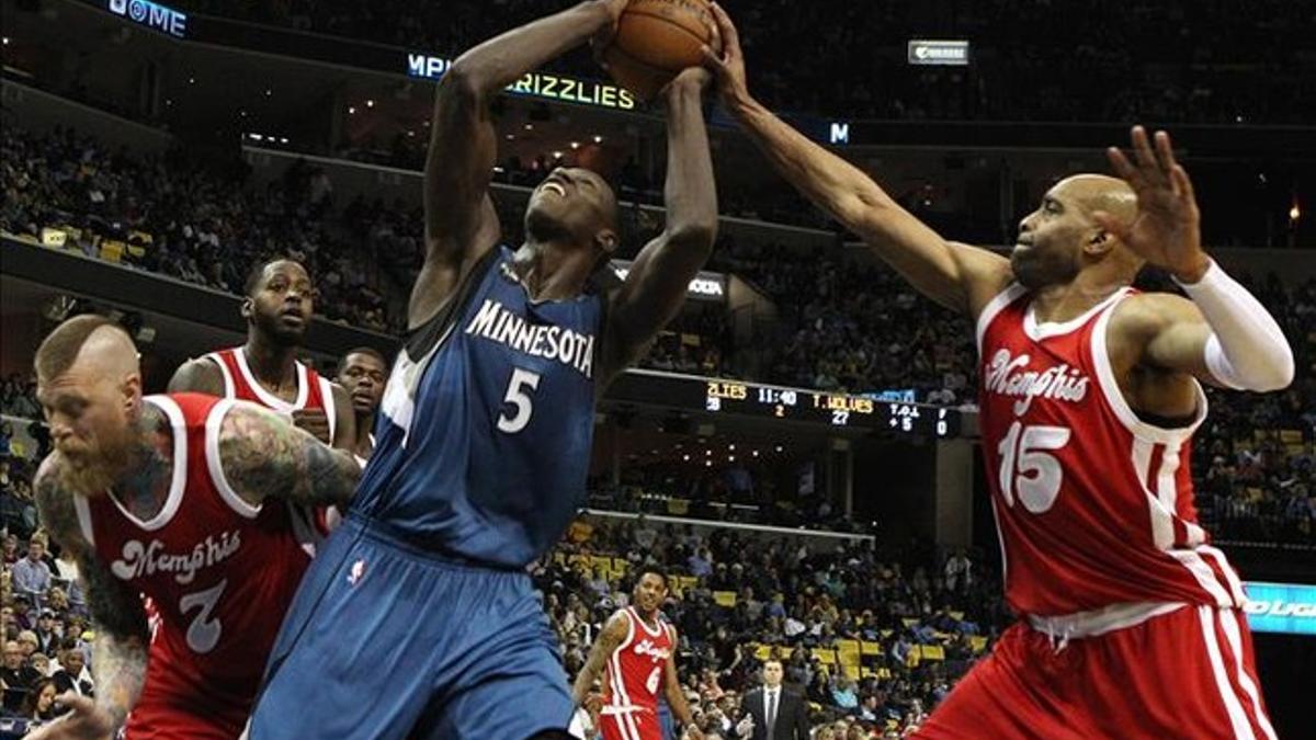 El jugador de Minnesota Timberwolves Gorgui Dieng (c), de Senegal, recibe una falta de Vince Carter (d) de Memphis Grizzlies hoy, viernes 19 de febrero de 2016, durante un juego de la NBA en FedExForum en Memphis (EE.UU.).