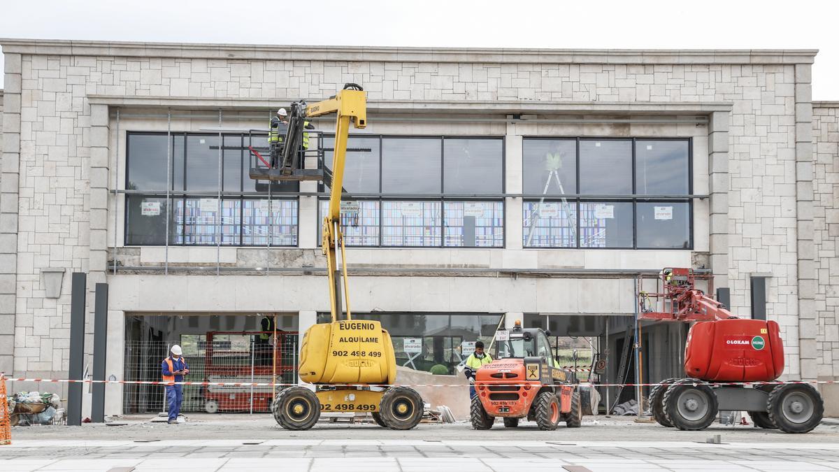 Operarios, este miércoles, trabajan en las labores de limpieza de la fachada principal del edificio de la estación de trenes de Cáceres.