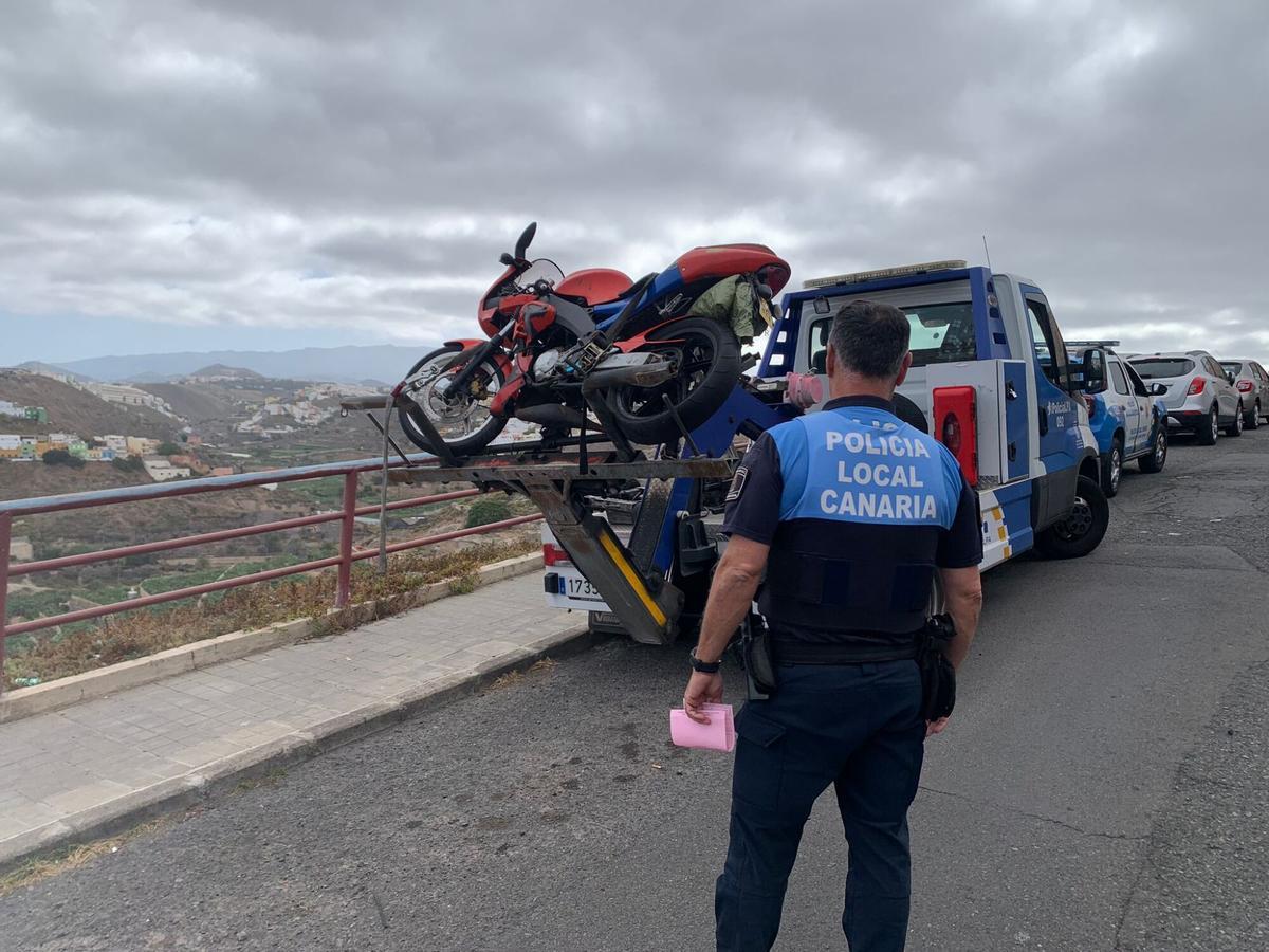 Un agente de la Policía Local de Las Palmas de Gran Canaria participa en la retirada de vehículos de una calle.