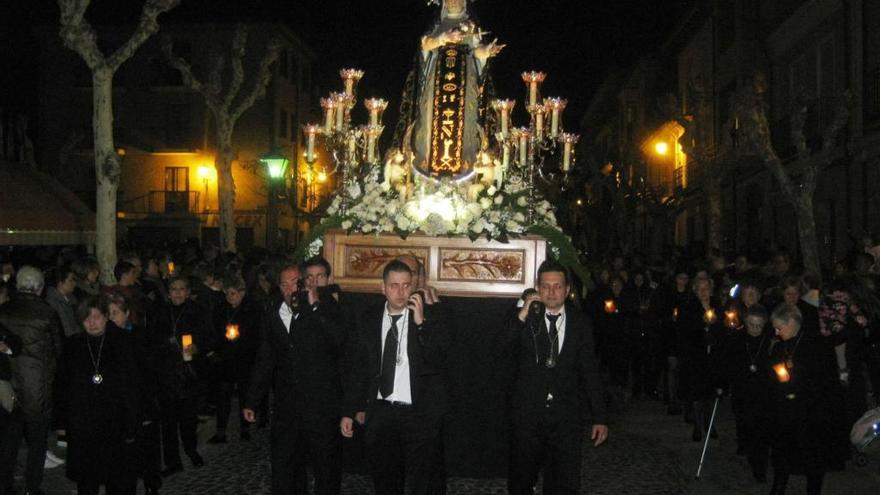 La Virgen portada por cargadores sale de la iglesia.