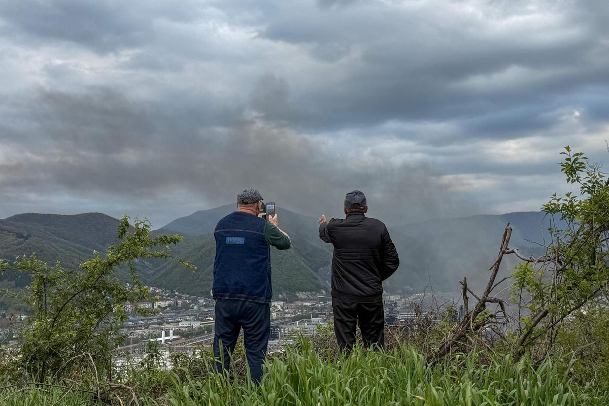 Residentes locales contemplan una columna de humo producto de recientes bombardeos de Ucrania elevándose al cielo en Tuapsé, el pasado 29 de abril.