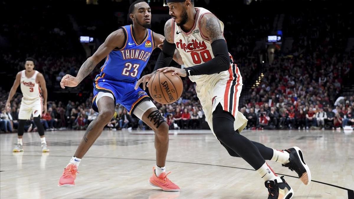 Carmelo Anthony conduce el balón en presencia de Terrance Ferguson