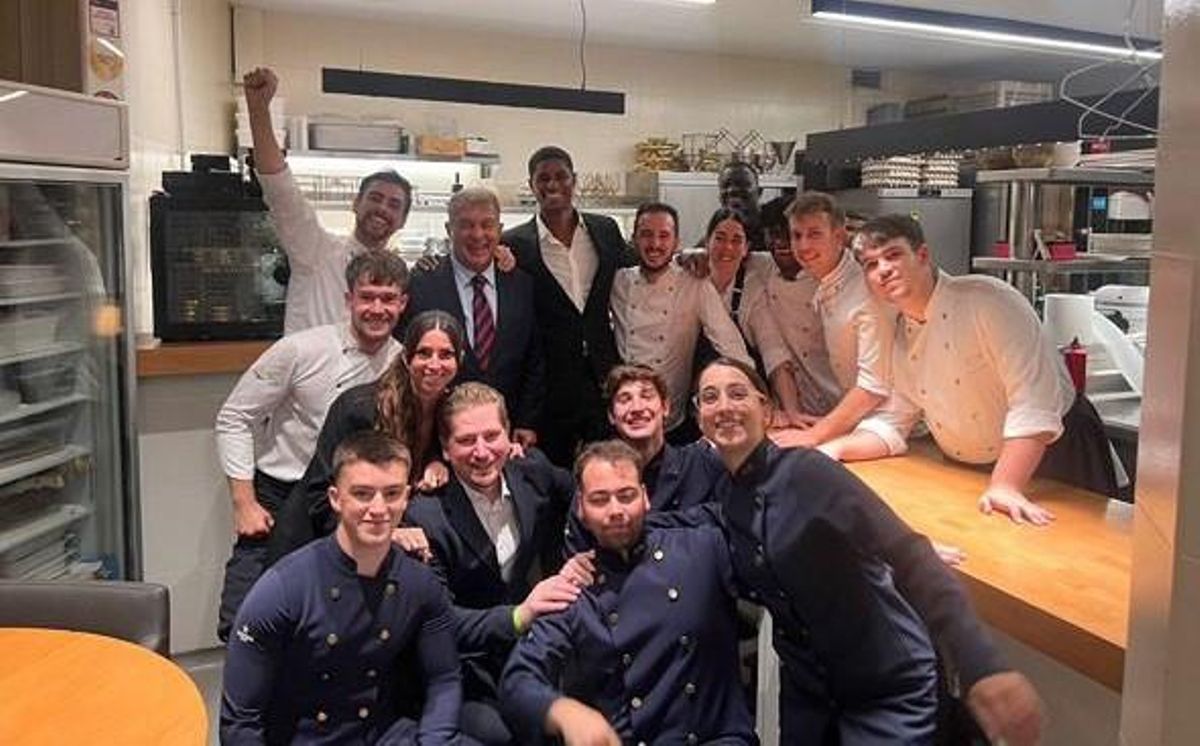 Al fondo Laporta y Rashford, con el equipo de cocina y sala del restaurante Amar, en Barcelona, la noche del miércoles.