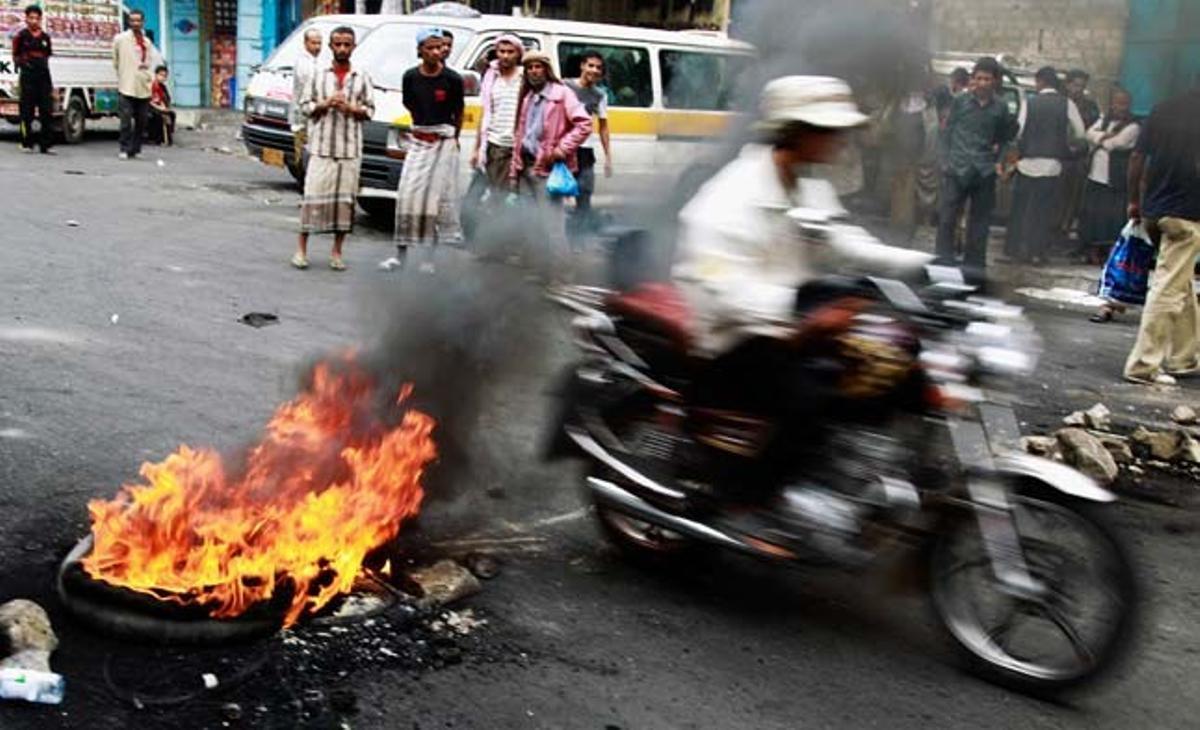 Un motociclista travessa una barricada formada per manifestants antigovernamentals en un carrer de Taiz, al sud del Iemen.