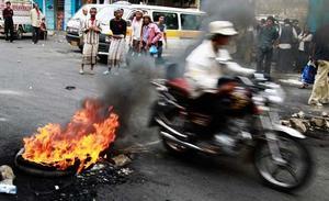 Un motociclista travessa una barricada formada per manifestants antigovernamentals en un carrer de Taiz, al sud del Iemen.