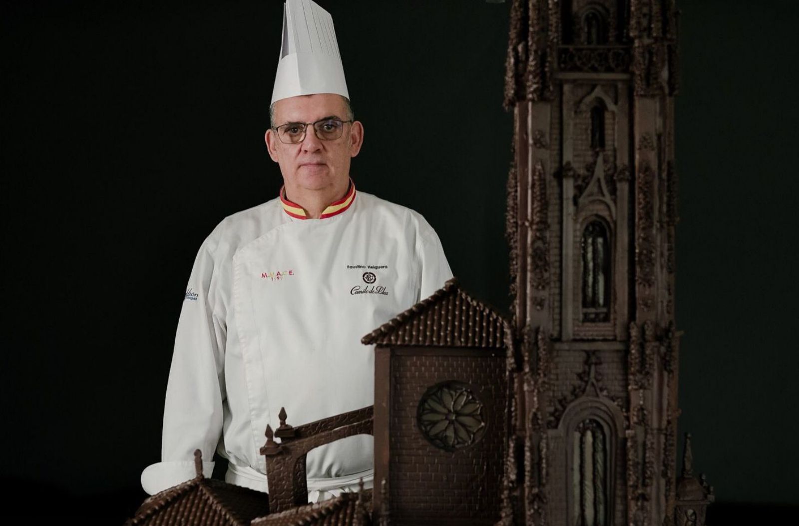 El maestro chocolatero Tino Helguera posa con la catedral de chocolate que elaboró tras 400 horas de trabajo en el obrador de Camilo de Blas. | LNE