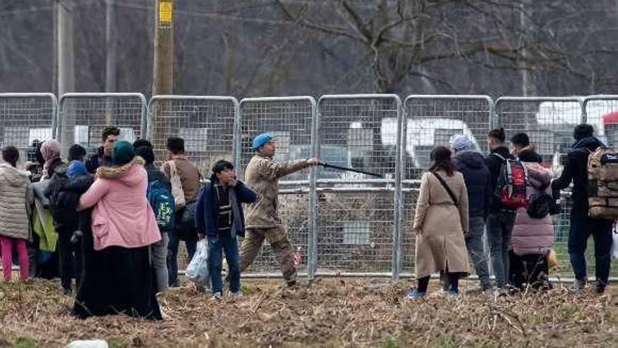 Un soldado turco dirige a migrantes en la frontera griega. // Reuters