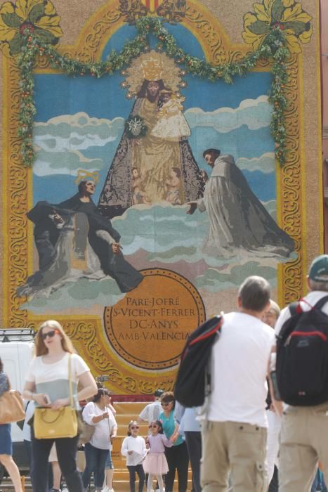 Numerosas personas acuden a la plaza de la Virgen de València para contemplar el tapiz floral