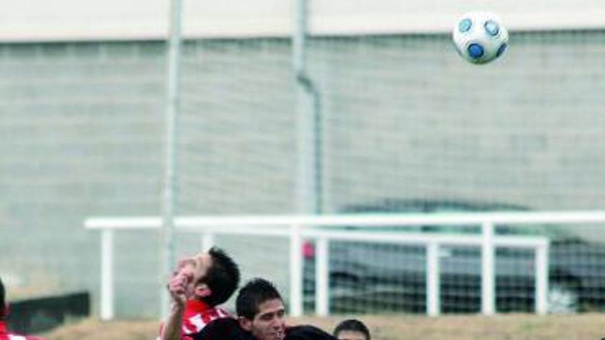Un jugador del Zamora B Valbusenda trata de ganar un balón aéreo.